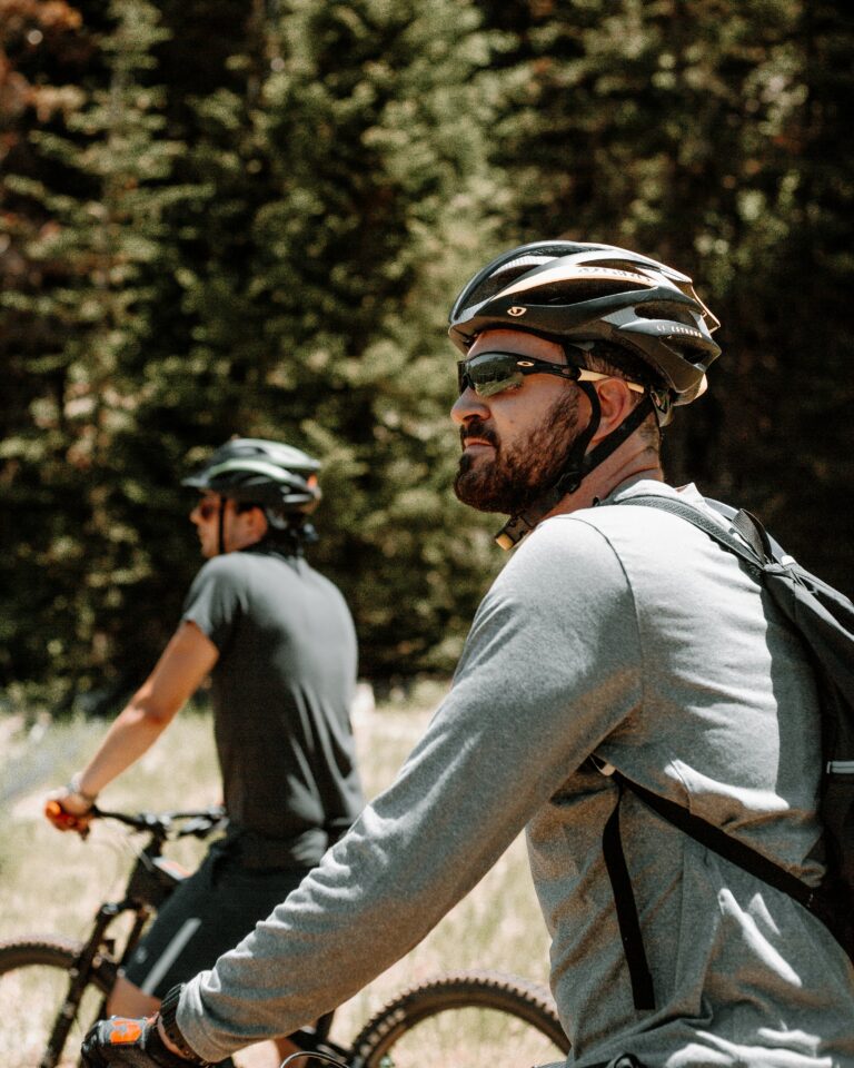 Cyklist med hjelm kører mountainbike i skov