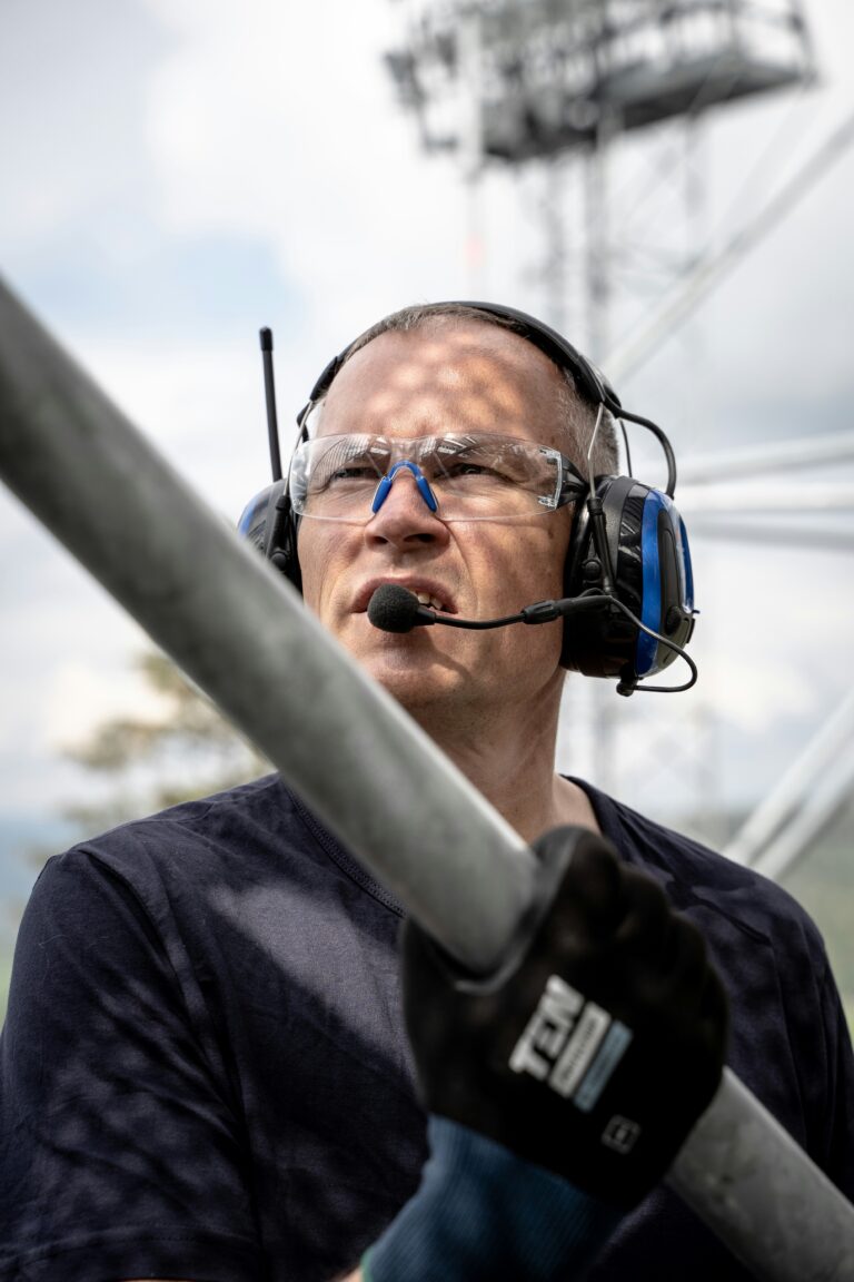 Tekniker med headset kommunikerer i industrimiljø