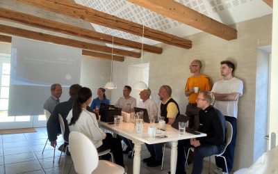 Medarbejdere i mødelokale omkring bord i uformelt arbejdsmiljø – sektion: Job hos Great Dane