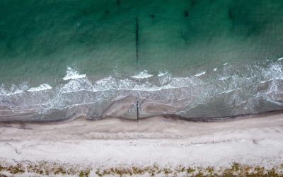 Luftfoto af bølger der skyller ind over sandstrand – sektion: Vores mission