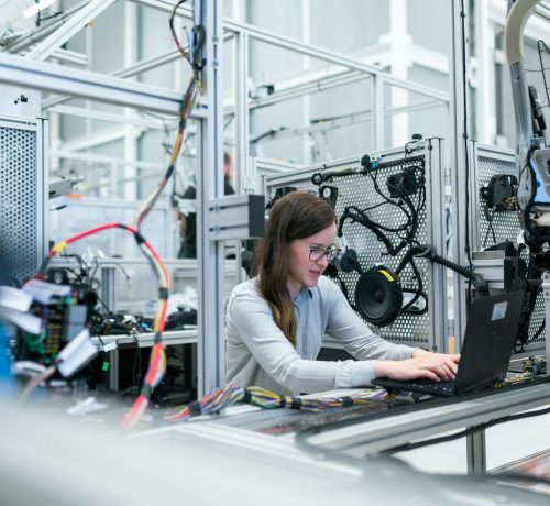 Tekniker arbejder på elektronik i laboratorie/produktionsmiljø